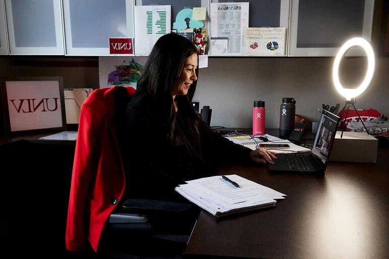 Renee Rivera-Ghelfi smiling while working at her computer.